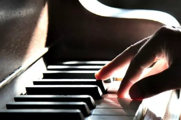 Hand playing piano keys